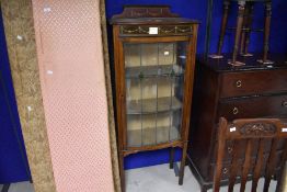 An Edwardian mahogany string inlaid display cabinet, having a shallow shaped back over the moulded