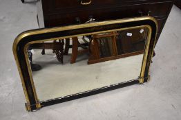 A 19th century ebonised and gilt over mantel mirror, of rectangular form with rounded upper corners,
