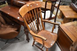 A 19th/20th century elm seated spindle back armchair, of traditional design with one-piece solid