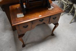 A reproduction figured mahogany lowboy, with quarter veneered and herring bone strung top with