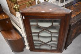 A George III astragal glazed mahogany corner cupboard, with canted corners and shaped internal