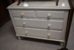 A late white painted Victorian pine chest of two short and two long drawers, each with turned knob