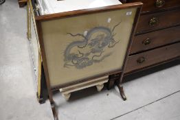 An early 20th century silkwork and mahogany fire screen, of traditional design with Chinese dragon