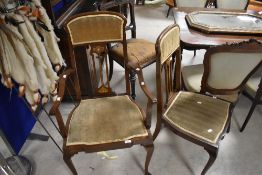 A pair of Art Nouveau mahogany salon or dining chairs (one being a carver chair) having inlaid