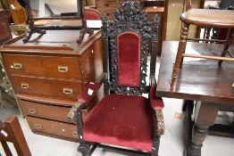 A large Victorian baroque carved and stained oak armchair, the shaped, carved and pierced crest with