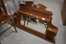 An early 20th pine and mahogany over mantel mirror, with shaped surmount, shelves and bevelled plate