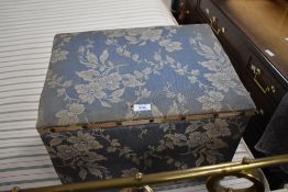 A vintage material covered box stool, of hinged rectangular form, covered in foliate patterned