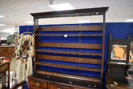 A George III oak dresser and rack, having a plain angled cornice over a frieze inset with hooks