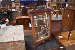 An antique mahogany framed bevelled easel mirror, with shaped surmount and scrolled feet 74cm x 49cm
