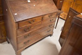 A George III mahogany bureau, of traditional fall-front design with two short and three long