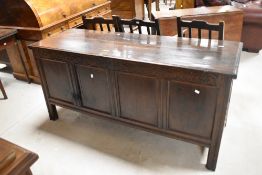 A large 18th century oak four panelled coffer, having a hinged oblong top enclosing the internal