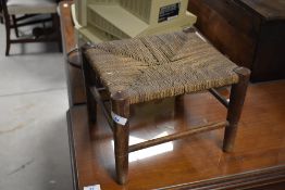 An Edwardian stained mahogany piano stool, with hinged and padded box seat between turned handles,