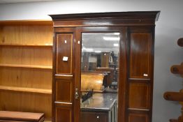 An early 20th century banded mahogany mirror door wardrobe, of traditional form with central door