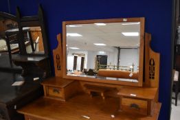 An attractive Edwardian golden oak dressing chest, having a rectangular bevelled mirror plate