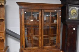 A modern reproduction glazed bookcase over cupboard, in the George III manner, with glazed doors
