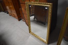 A modern rectangular gilt framed wall mirror, with moulded scroll decoration 100cm x 71cm