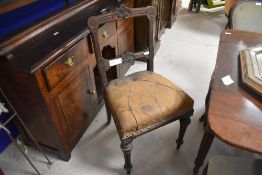 A 19th century mahogany dining chair, having a shaped and stylised foliate carved top rail and