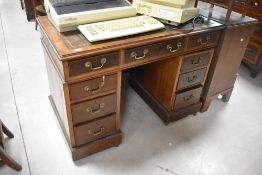 A 20th century reproduction mahogany pedestal desk, of traditional arrangement with inset tooled