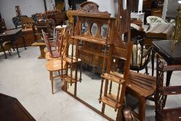 An Edwardian mahogany over-mantel mirror having an arched and stipple carved crest rail over three
