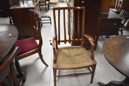 A well proportioned early 20th century string seated mahogany armchair, with shaped slatted back,