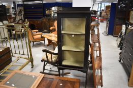An Edwardian stained mahogany display cabinet, having a shallow moulded back and rectangular top