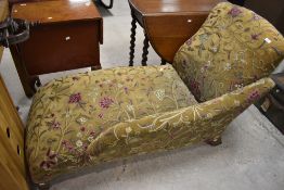An early 20th century design chaise longue, of traditional design upholstered in foliate crewel work