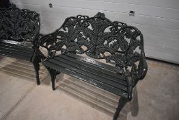 A pair of heavy cast iron Coalbrookdale type ferm pattern garden benches, each with slatted seats,