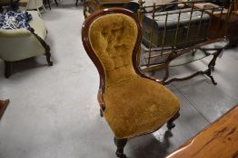 A Victorian mahogany spoon back nursing chair, of typical design with patterned mustard colour