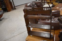 A small oak three tier wall shelf, with shaped and pierced tip rail and shaped ends, pegged