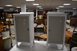 A pair of attractive white and grey painted bedside cabinets of traditional design with carved