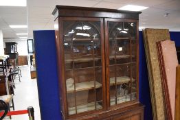 A 19th century glazed mahogany bookcase over cupboard, having a moulded cornice and plain frieze