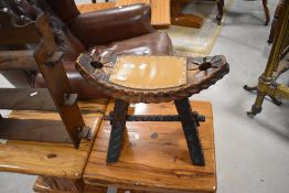 A small decorative notch carved stool, the elliptical seat with studded tan leather surface 41cm x