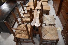 A set of six rush seated chapel chairs, of traditional design with book trough to back, seat