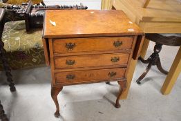 A reproduction burr-walnut bedside lamp table/chest, the rectangular top with hinged flap to each
