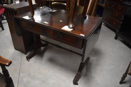 A mahogany regency design sofa table, the reeded rectangular top with rounded flaps over two