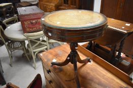 A reproduction mahogany pedestal drum table, of circular form with inset tooled leather surface over