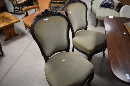 A group of four French Louis XV style dining chairs, having foliate carved crest rails over the