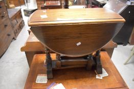 A reproduction oak drop leaf, gate legged occasional table, with moulded edge detail, turned