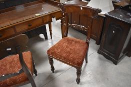 A pair of Victorian mahogany dining chairs, having concave scroll end top rails over scrolled mid