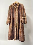 A vintage De Bella Fashion Perfect Furs coat in golden brown gradient hide, with brown satin lining,