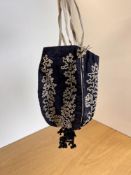 A Regency period reticule purse in black taffeta with ivory cord embroidery depicting curling ferns,