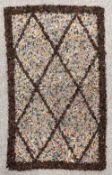 A vintage handmade rag rug with a deep pile, warm, deep brown border and central lattice design, a