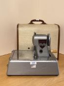 A vintage British Made SeamMaker hand-crank sewing machine, in sleek metal and chrome mid-century