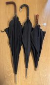 Three antique and vintage mourning umberellas, a British Made with leather covered handle and