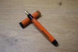 The Coral King Oversize lever fill fountain pen in Coral with broad cap band having Warranted 1st