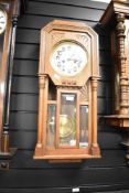 A large early 20th-century Westminster Ting Tang oak wall clock, having Arabic hours, featuring