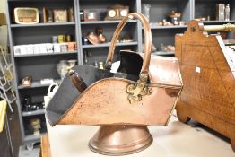 A 19th century copper coal scuttle, of angular form with swing over handle, rolled rim and spreading