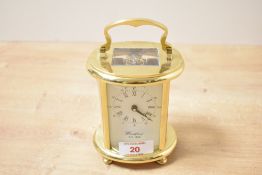 A 20th-century Woodford (est. 1860) brass corniche-style oval carriage clock, the dial with Roman