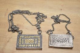 Two late 19th-century Omani white metal 'hirz' Koran boxes, featuring book-shaped amulets worn for
