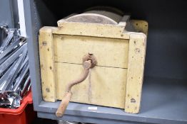 A 19th-century wooden butter churn with a hand crank mechanism, featuring a rectangular body and a
